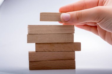 Beyaz arka planda ahşap domino taşları var.