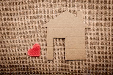 Kalp şekli bir tuval arka plan ile kağıt ev yanında