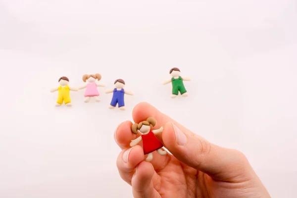 Hand Hält Bunt Gekleidete Kinderfigur Auf Weißem Hintergrund — Stockfoto