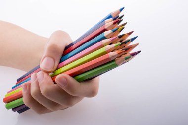 Beyaz arkaplanda el ele tutuşan renkli kalemler