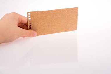 Bir defter--dan yırtık bir kağıt tutan el