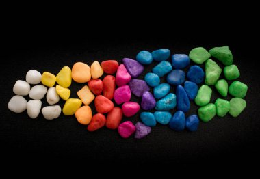 Siyah arkaplanda küçük renkli çakıl yığınları