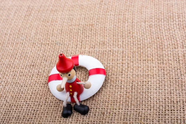 Pinokyo bebeği tuvaldeki can yeleğine bağlı.