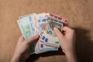 El ele tutuşan Amerikan doları banknotları ahşap arka planda izole edilmiş.