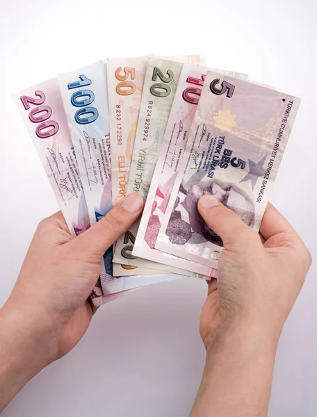 Turksh Lirası banknotlar beyaz arka plan üzerinde tutan el