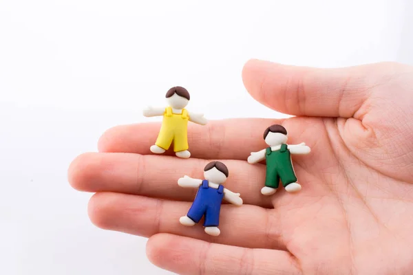 Hand Houden Kleurrijke Gekleed Kinderen Figuren Een Witte Achtergrond — Stockfoto