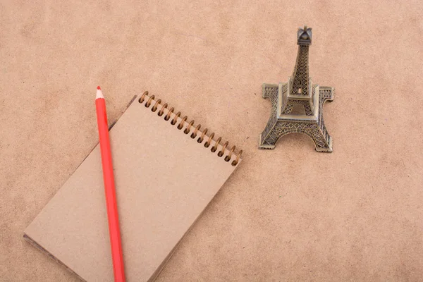 Little Model Eiffel Tower Notebook Pencil Brown Background — Stock Photo, Image