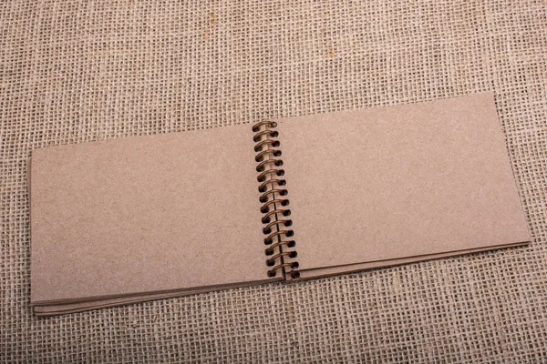 棕褐色笔记本放置在画布背景 — 图库照片