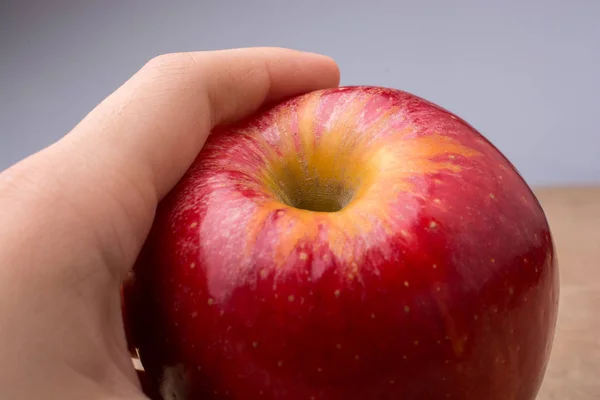 Hand Hält Einen Frischen Roten Apfel Auf Einem Holz — Stockfoto