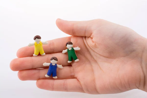 Hand Hält Bunt Gekleidete Kinderfiguren Auf Weißem Hintergrund — Stockfoto