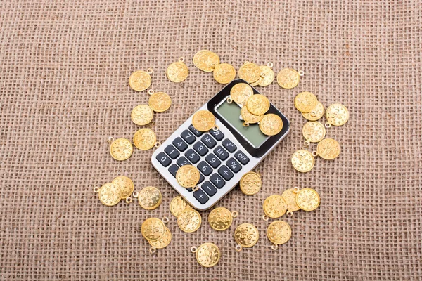 Fake gold coins around the calculator on canvas