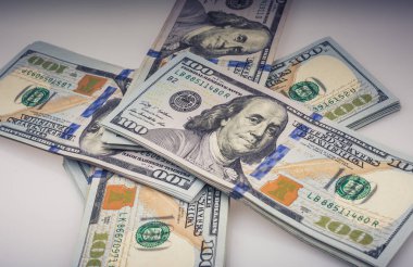 Beyaz zemin üzerine yerleştirilmiş Amerikan 100 dolarlık banknot demetleri