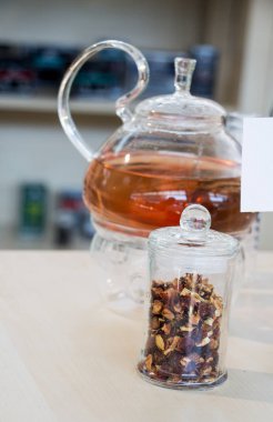 Cam çaydanlıkta demlenmiş bitki çayı ve şişede çay bitkisi.