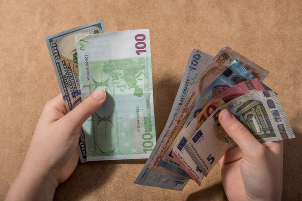 Hand holding American dollar  banknotes isolated on wooden background