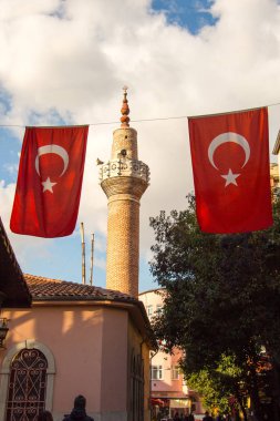 Bir minare bir iple bir direğe Türk ulusal bayrak dayan