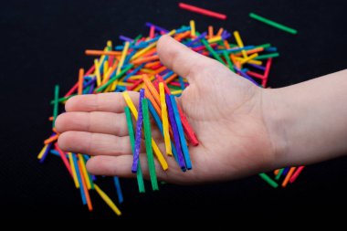 Beyaz arka planda yaratıcılık için renkli tahta çubuklarla oynayan çocuk