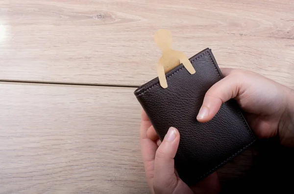 Man shape cut out of paper in wallet in hand