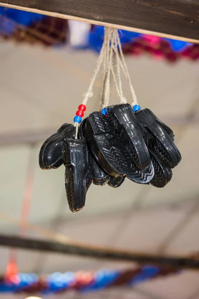 Black plastic miniature shoes hanging in the view