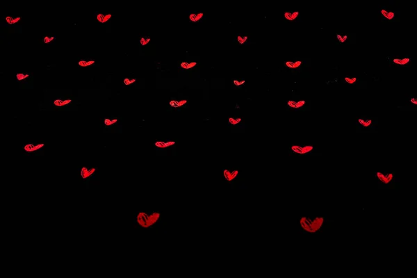 Black fabric background with red hearts — Stock Photo, Image