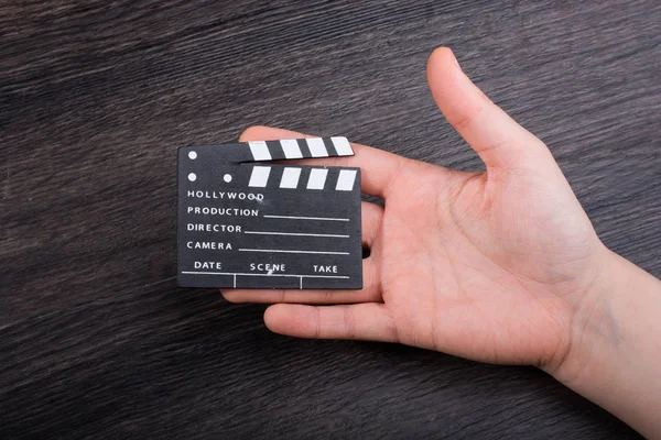 Hand hält kleinen Filmklöppel in der Hand — Stockfoto