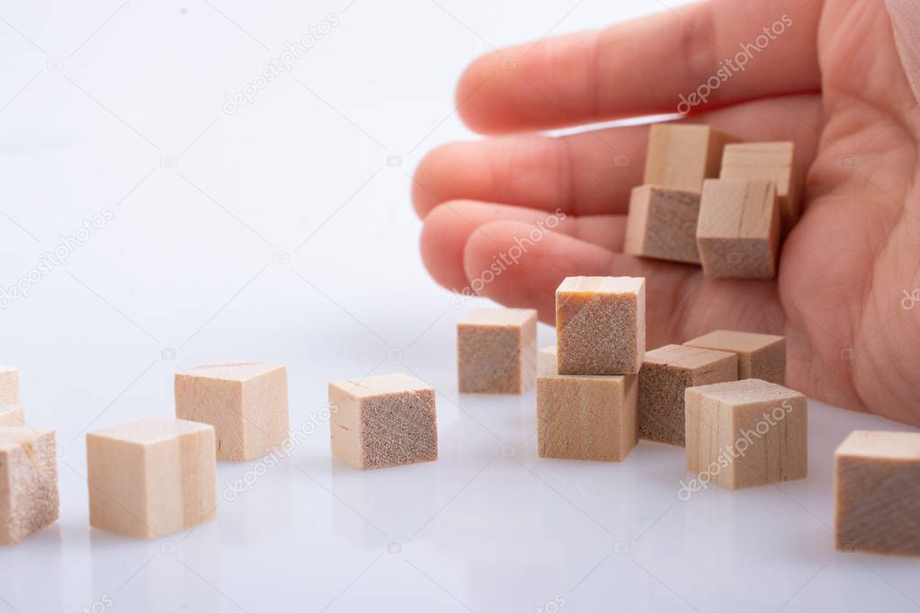 Hand playing with wooden toy cubes as  educational games 