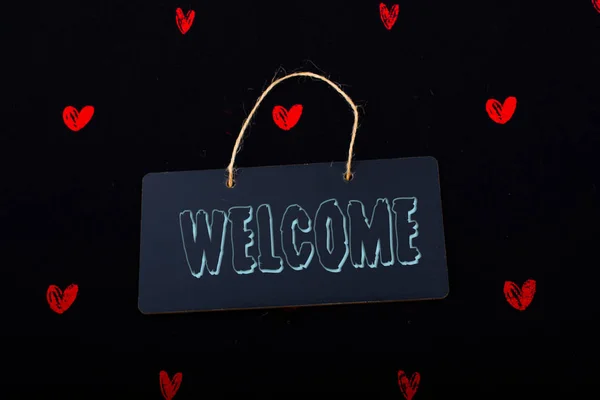 Welcome on black notice board  with red hearts around — Stock Photo, Image