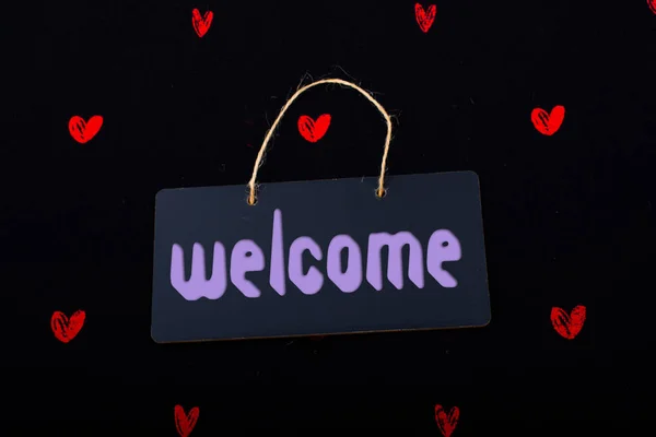 Welcome on black notice board  with red hearts around — Stock Photo, Image