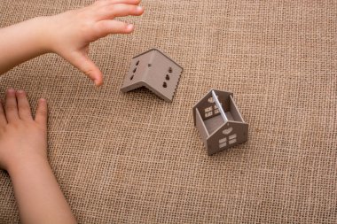 Bir tuval üzerine bir model ev tutan çocuk
