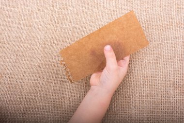 Ahşap bir arka planda bir parça kağıt tutarak el