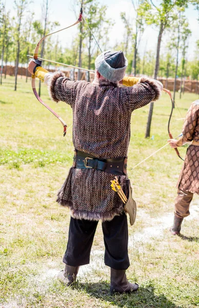 Bogenschütze in traditioneller Kleidung schießt einen Pfeil — Stockfoto