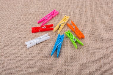 Bir keten tuval arka plan üzerine yerleştirilen clothespins dönüştürün