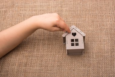 Bir tuval üzerine bir model ev tutan çocuk