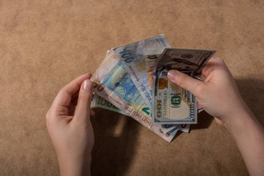 Amerikan Doları üzerinde ahşap arka plan izole tutan el