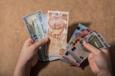 Amerikan Doları üzerinde ahşap arka plan izole tutan el