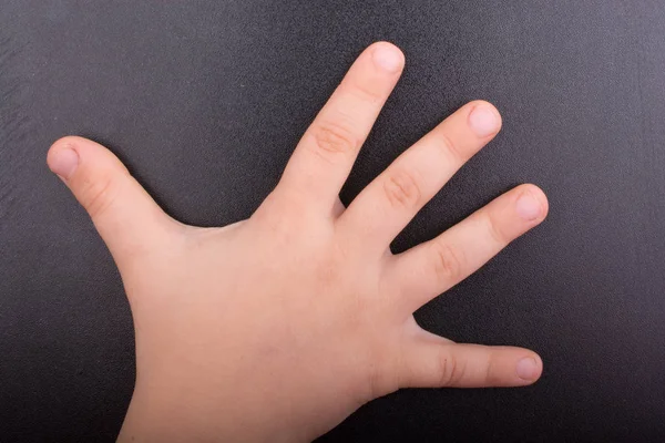 Kisgyermek kezét sötét háttérrel — Stock Fotó