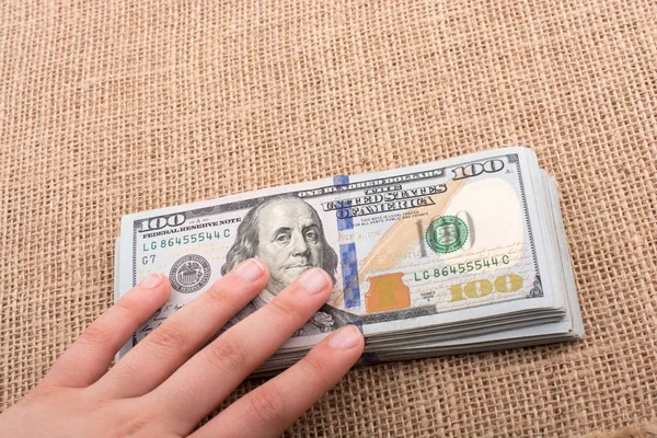 Hand holding banknote bundle of US dollar in hand