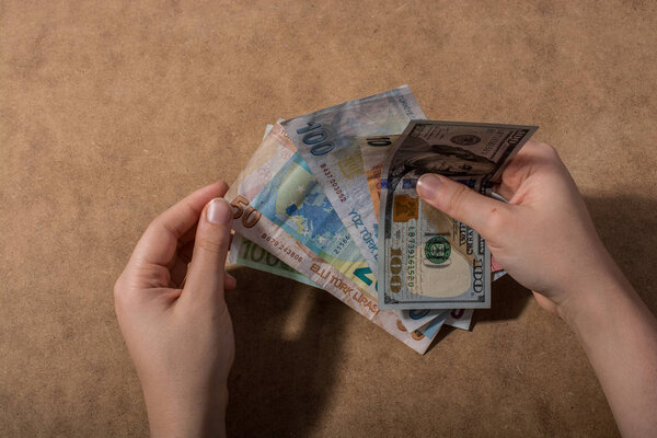 Hand holding American dollar  isolated on wooden background