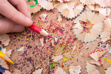 Bir defter üzerinde renk kalem tutan el