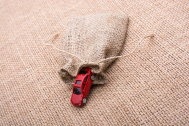 Bir tuval üzerine keten bir çuval arabadan kırmızı oyuncak