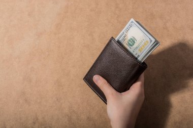Amerikan Doları üzerinde ahşap arka plan izole tutan el
