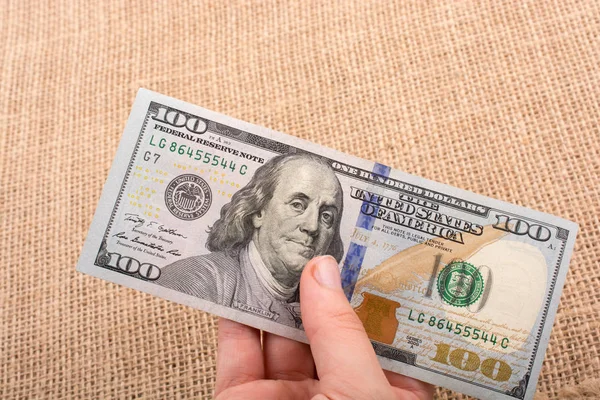 Hand hält Geldbündel mit US-Dollar in der Hand — Stockfoto