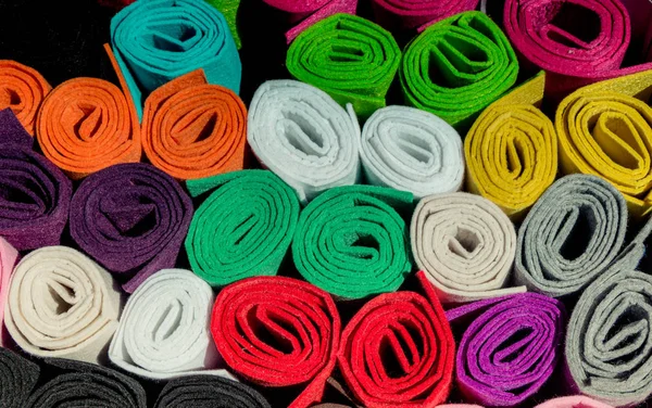 Dozens of colorful fabric rolls in display