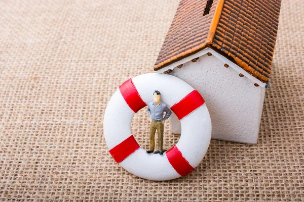 Model house and a life preserver with a man figure