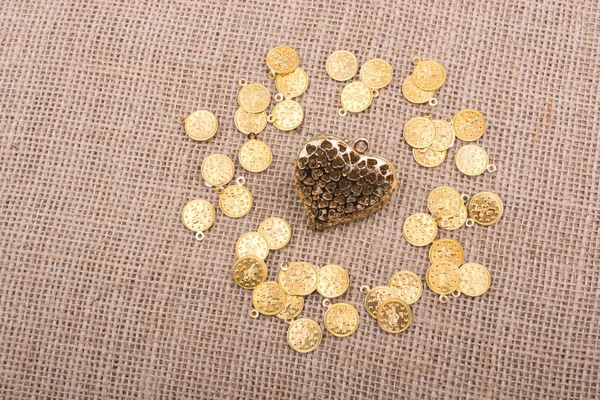 Gold color heart with fake coins around