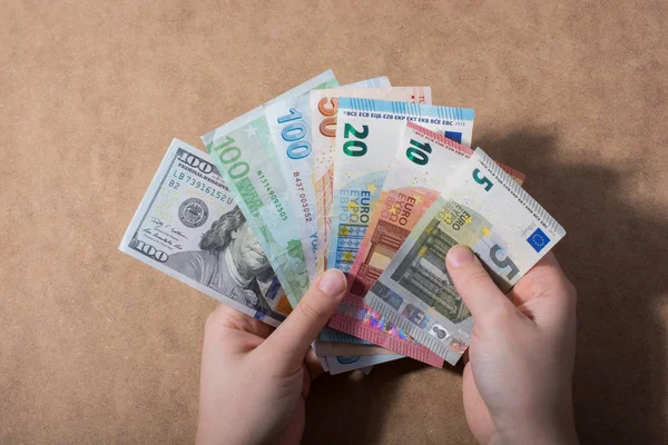 Amerikan Doları üzerinde ahşap arka plan izole tutan el