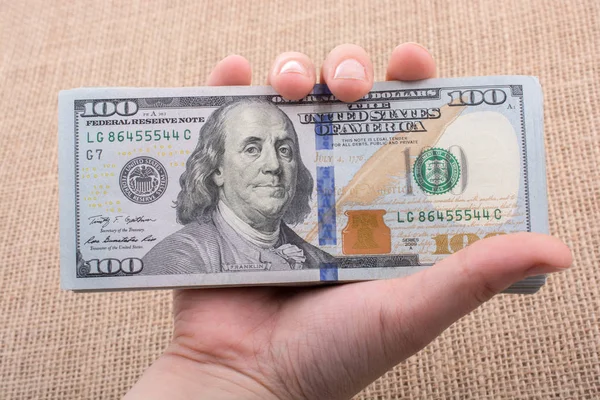 Paquete de billetes de mano de dólar estadounidense en mano — Foto de Stock