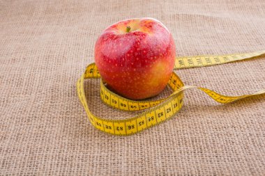 Bir ölçüm bandı üstünde o ile kırmızı elma