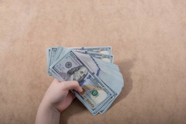 Amerikan Doları üzerinde ahşap arka plan izole tutan el