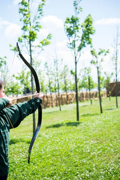 Archer en ropa tradicional disparando una flecha — Foto de Stock