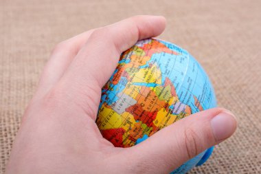 Tuval üzerinde bir küre tutan el